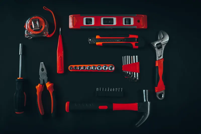 An assortment of hand tools on a dark work surface